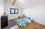 This bright and airy bedroom offers a serene retreat with its minimalist design and natural light.