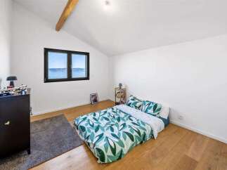 This bright and airy bedroom offers a serene retreat with its minimalist design and natural light.