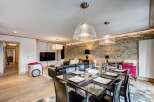 Experience luxury living in this stunning property, featuring a modern dining area with a glass table and stylish black chairs.