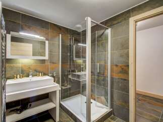 Step into luxury with this stunning bathroom featuring a modern glass shower enclosure and elegant tile work.