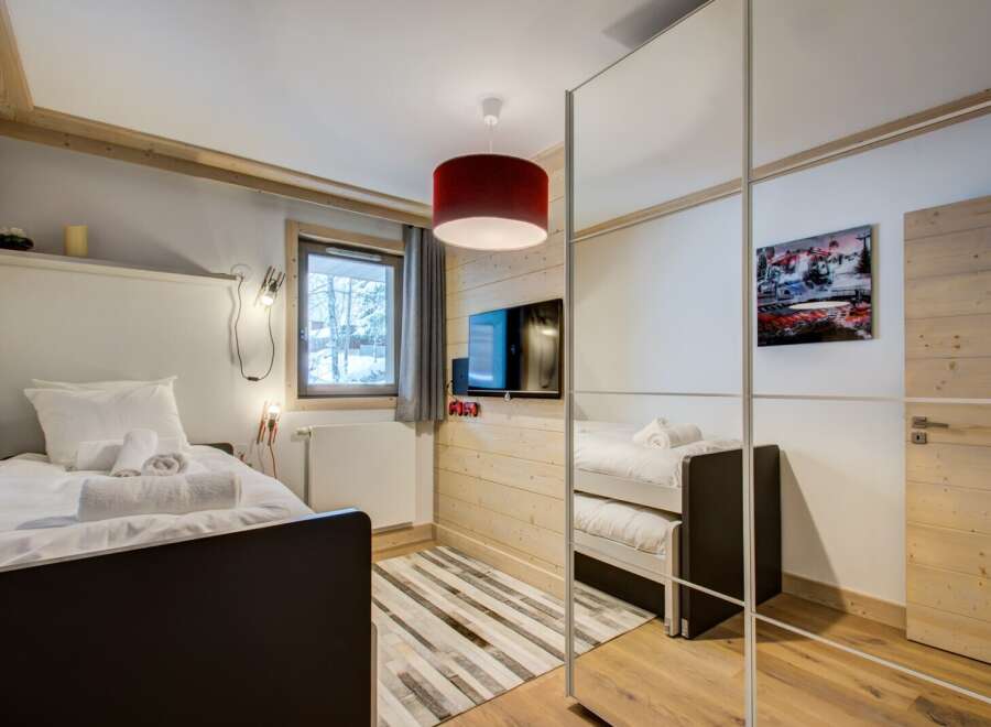 This cozy bedroom features a modern design with wooden accents, creating a warm and inviting atmosphere.