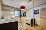 This cozy bedroom features a modern design with wooden accents, creating a warm and inviting atmosphere.