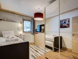 This cozy bedroom features a modern design with wooden accents, creating a warm and inviting atmosphere.