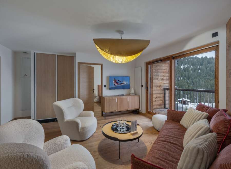 Experience luxury living in this stunning property, featuring a cozy living room with plush seating and a modern entertainment setup.