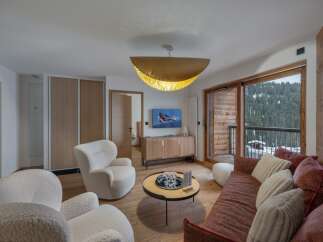 Experience luxury living in this stunning property, featuring a cozy living room with plush seating and a modern entertainment setup.
