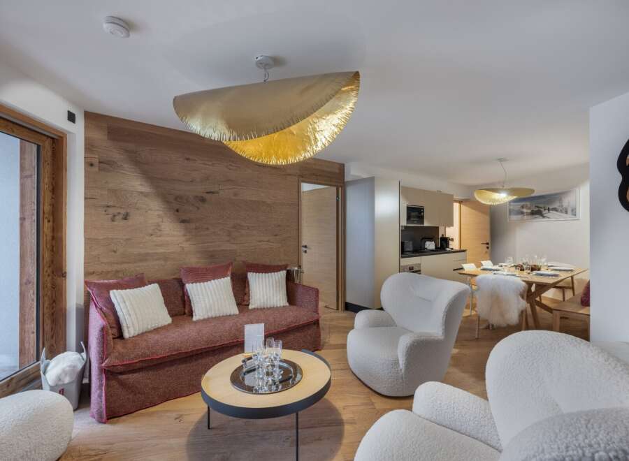 Experience luxury living in this stunning property, featuring a beautifully designed living space with a cozy sofa and stylish armchairs.