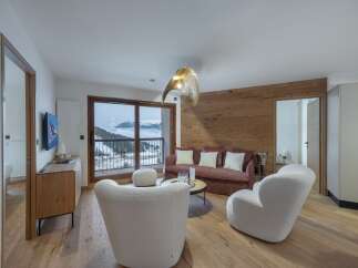 Experience luxury living in this stunning property, featuring a cozy living room with a fireplace and large windows offering breathtaking mountain views.