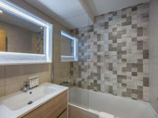 This modern bathroom features a sleek design with a combination of light and dark tiles, creating a stylish and inviting atmosphere.