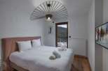 Experience luxury in this stunning bedroom featuring a plush bed and a unique, modern light fixture.