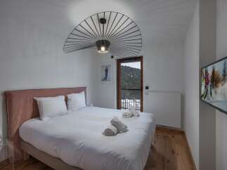 Experience luxury in this stunning bedroom featuring a plush bed and a unique, modern light fixture.