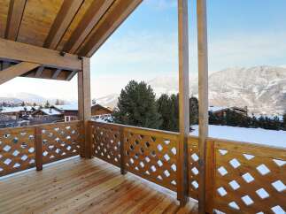 Enjoy breathtaking mountain views from this stunning wooden balcony.