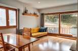 Step into this inviting living space, featuring a warm, wooden dining table perfect for gatherings.