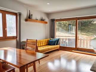 Step into this inviting living space, featuring a warm, wooden dining table perfect for gatherings.