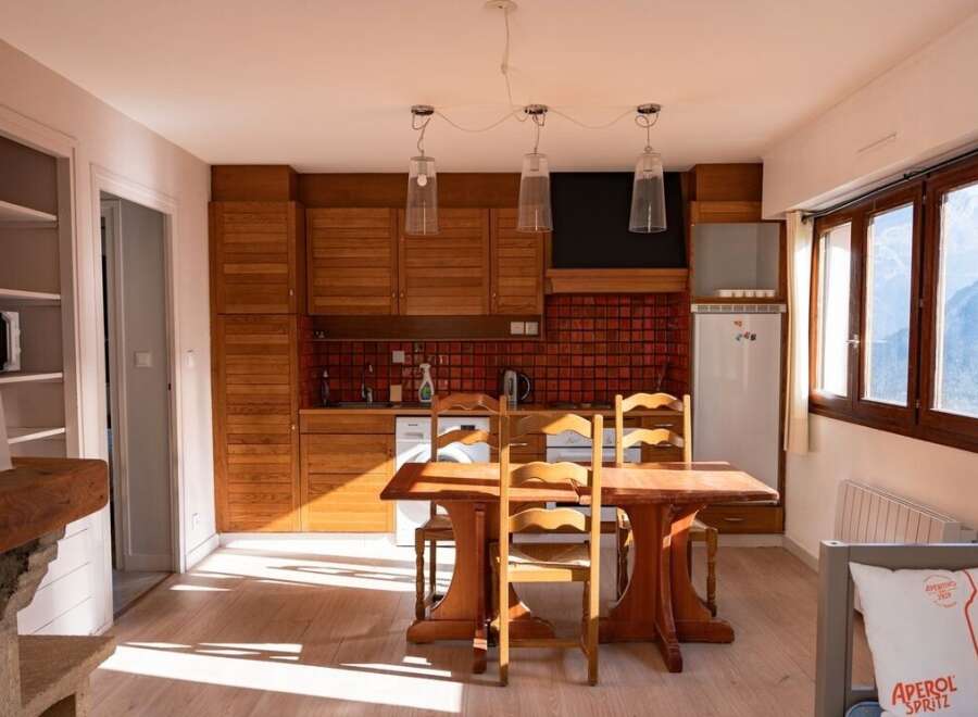 Discover this charming property featuring a cozy kitchen with wooden cabinets and a dining area perfect for gatherings.