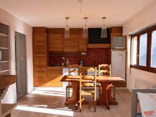 Discover this charming property featuring a cozy kitchen with wooden cabinets and a dining area perfect for gatherings.