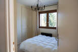 This cozy bedroom features a comfortable bed with a fluffy white comforter, perfect for a relaxing retreat.