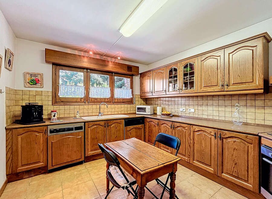 This charming kitchen boasts classic wooden cabinetry, offering ample storage and a warm, inviting atmosphere.