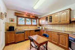 This charming kitchen boasts classic wooden cabinetry, offering ample storage and a warm, inviting atmosphere.