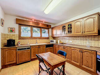 This charming kitchen boasts classic wooden cabinetry, offering ample storage and a warm, inviting atmosphere.