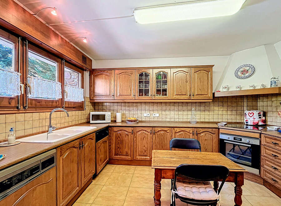 Step into this charming kitchen, featuring warm wooden cabinetry and ample counter space.
