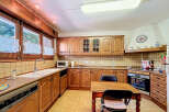 Step into this charming kitchen, featuring warm wooden cabinetry and ample counter space.