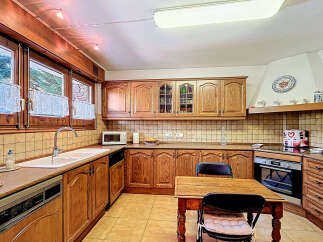 Step into this charming kitchen, featuring warm wooden cabinetry and ample counter space.