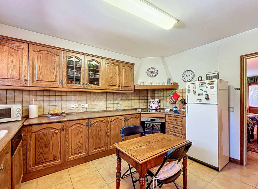 This charming kitchen boasts classic wooden cabinetry, offering ample storage and a warm, inviting atmosphere.