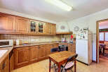 This charming kitchen boasts classic wooden cabinetry, offering ample storage and a warm, inviting atmosphere.