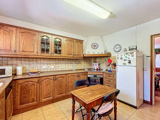 This charming kitchen boasts classic wooden cabinetry, offering ample storage and a warm, inviting atmosphere.