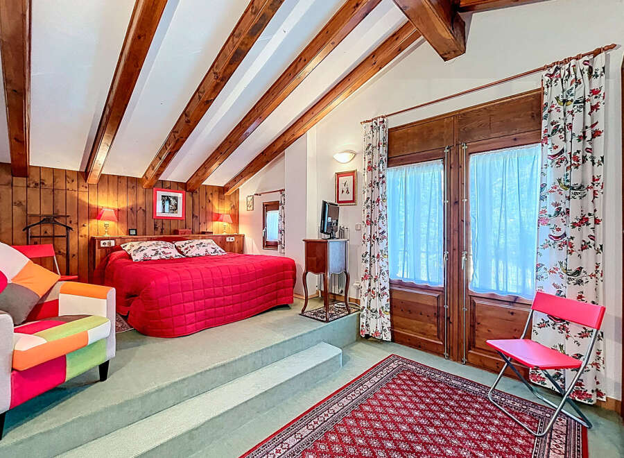 This charming bedroom boasts a cozy ambiance with its wooden beams and warm lighting.