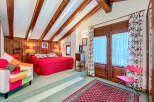 This charming bedroom boasts a cozy ambiance with its wooden beams and warm lighting.