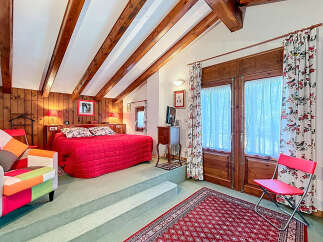 This charming bedroom boasts a cozy ambiance with its wooden beams and warm lighting.