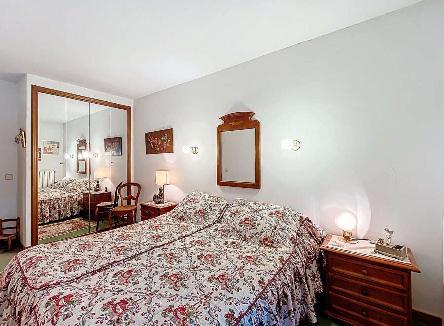 Discover the charm of this cozy bedroom, featuring a comfortable bed with a floral patterned bedspread.