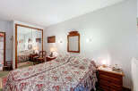 Discover the charm of this cozy bedroom, featuring a comfortable bed with a floral patterned bedspread.