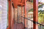 This stunning property boasts a charming balcony with intricate wooden detailing and a rustic stone facade.