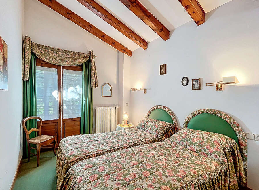 This charming bedroom features two twin beds with floral bedding, perfect for guests or a cozy retreat.