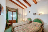 This charming bedroom features two twin beds with floral bedding, perfect for guests or a cozy retreat.