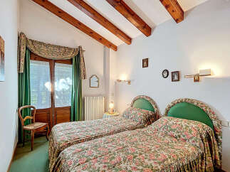 This charming bedroom features two twin beds with floral bedding, perfect for guests or a cozy retreat.