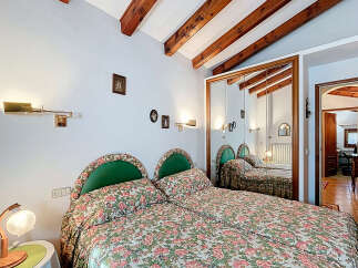 Discover the charm of this inviting bedroom, featuring a cozy double bed adorned with floral bedding and complemented by stylish green headboards.
