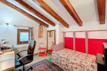 This charming bedroom features a cozy atmosphere with exposed wooden beams and a unique design.