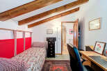 Discover the charm of this cozy bedroom, featuring a unique sloped ceiling with exposed wooden beams.