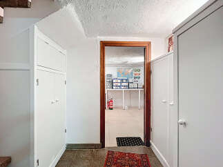 Discover the charm of this property, featuring a well-lit hallway with ample storage solutions.