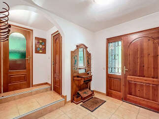 Step into this inviting entryway, featuring a charming wooden door and a decorative wall-mounted mirror.
