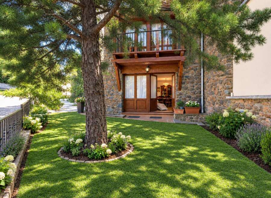 Charming stone-clad home with a welcoming wooden entrance and a balcony overlooking a lush green lawn.