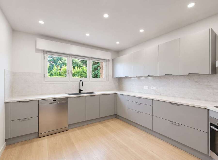 Discover this modern kitchen featuring sleek, light gray cabinetry and a matching dishwasher.