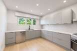 Discover this modern kitchen featuring sleek, light gray cabinetry and a matching dishwasher.