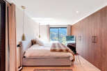 Experience luxury in this stunning bedroom, featuring a plush bed and elegant pendant lighting.