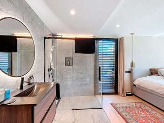 Experience luxury living in this stunning property featuring a modern bathroom with a sleek shower and a stylish vanity.
