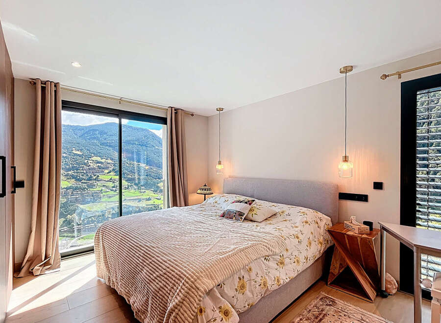 Experience luxury living in this stunning bedroom with breathtaking mountain views.