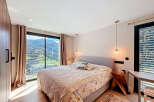 Experience luxury living in this stunning bedroom with breathtaking mountain views.